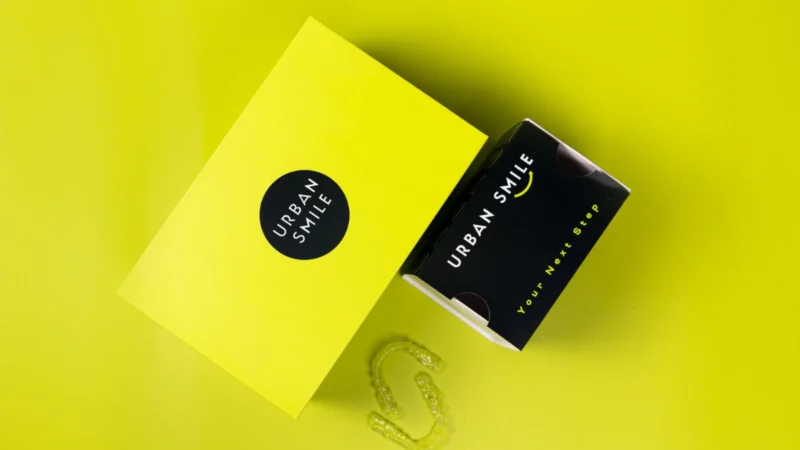 Photo of Urban Smile Clear Aligner box and refinement aligner box with clear aligners next to them