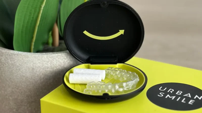 Clean Urban Smile clear aligners sitting in their case on top of the Urban Smile aligner box
