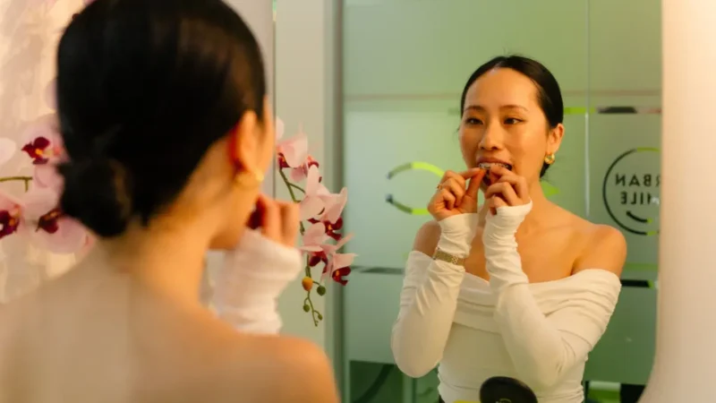 Patient putting in clear aligners at Urban Smile