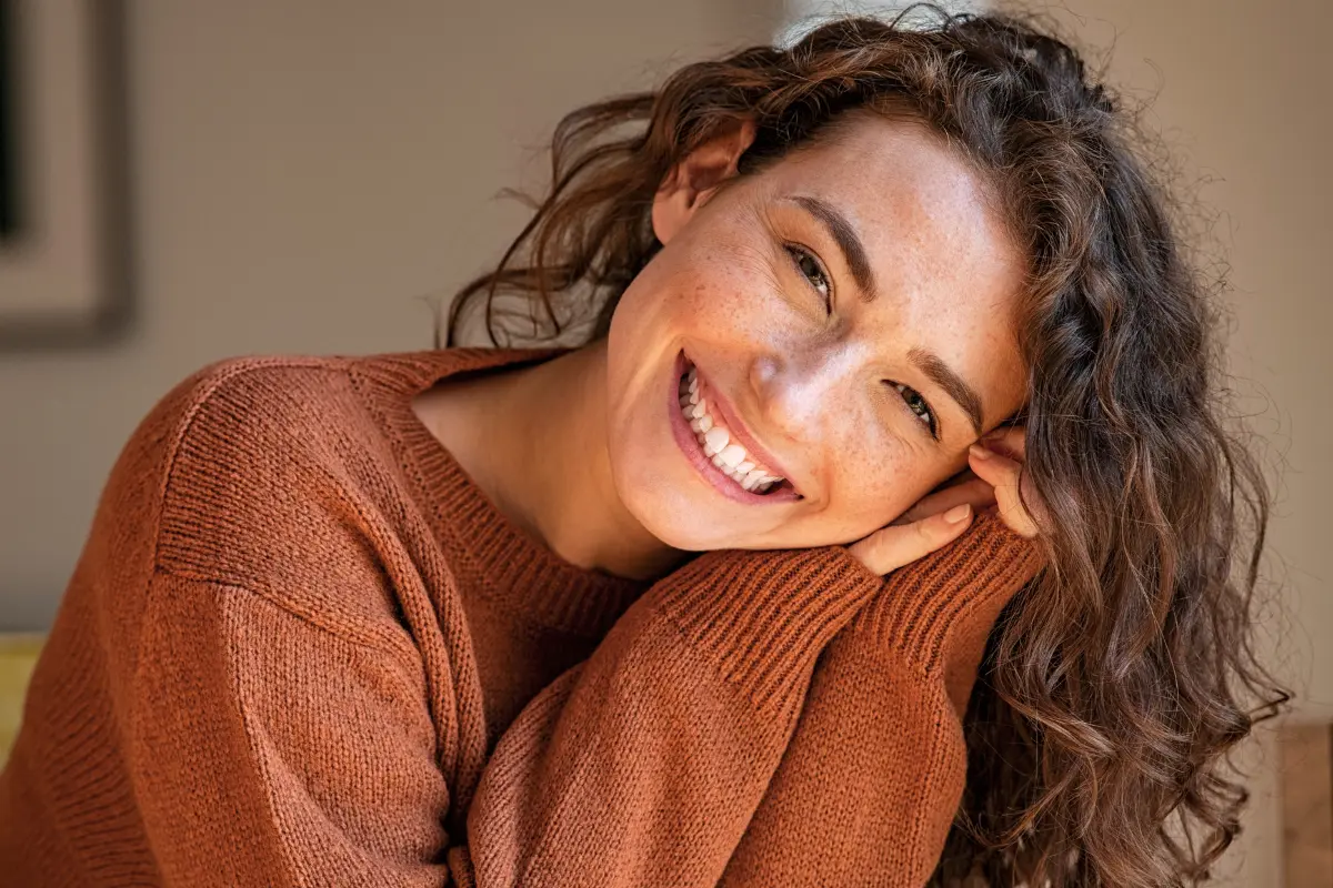 Woman in cosy brown jumper smiling