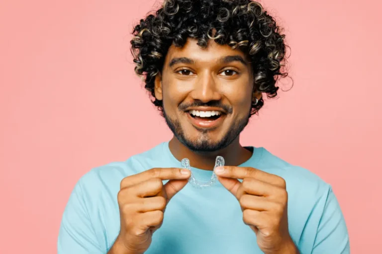 Adult man holding up clear aligner