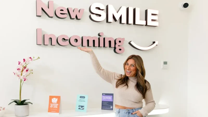 Adult woman gesturing to New SMILE Incoming sign at Urban Smile Hawthorn
