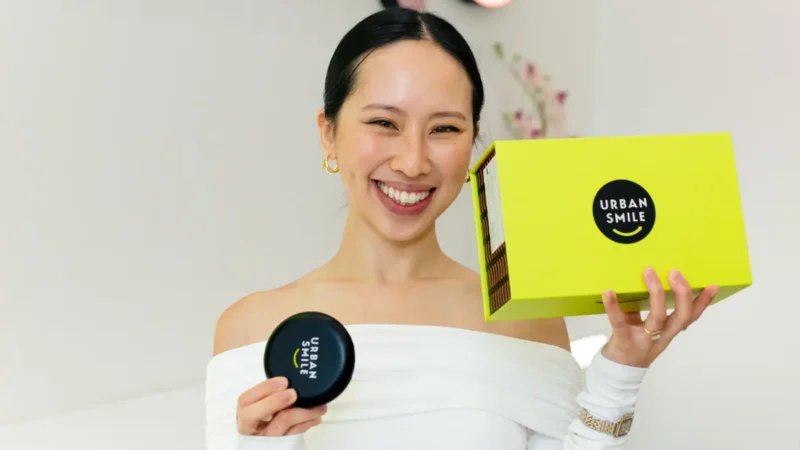 Influencer @lovecherriiee holding up her Urban Smile clear aligner box and aligner case
